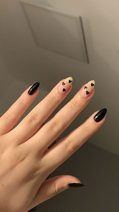 a woman's hand with black and white nail polish on it, holding up her nails