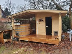 a small wooden house with a hot tub on the deck and an outside shower area