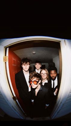 a group of young people standing next to each other in front of a door with the caption help campus / 2012