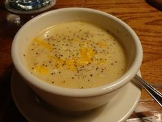 a white bowl filled with soup on top of a plate