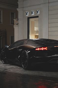 a black sports car parked in front of a building