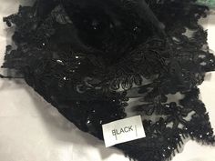 a black lace piece with a tag that says black on the front and back of it