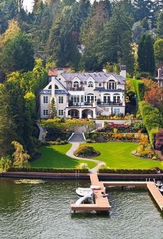 an aerial view of a house on the water with a dock in front of it