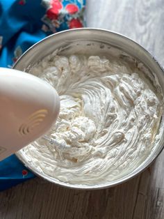 an electric mixer mixing white cream in a bowl