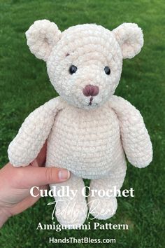 a hand holding a white crocheted teddy bear in front of green grass with the caption cuddly crochet