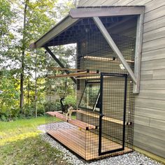 a chicken in a cage on the outside of a house