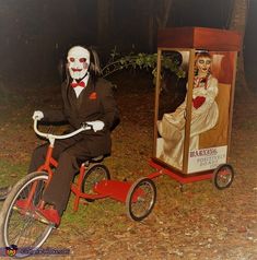 a creepy man riding a tricycle next to a poster on the side of it