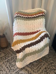 a crocheted blanket sitting on top of a wooden chair