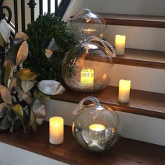 candles are sitting on the steps next to some glass balls