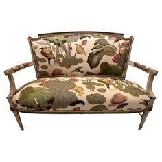 an upholstered chair with flowers and leaves on it