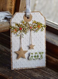 a christmas tag hanging from the side of a window sill with decorations on it