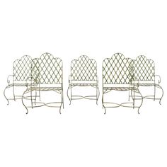 four wrought iron garden chairs with white cushions