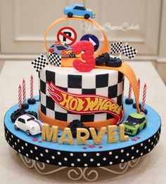 a birthday cake decorated with cars and candles