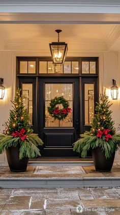 two large planters with christmas wreaths are in front of a door