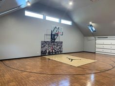 an indoor basketball court in the middle of a room with hardwood floors and white walls