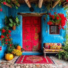 a blue house with red doors and flowers