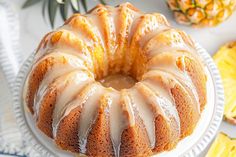 a bundt cake sitting on top of a white plate next to pineapples