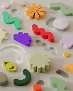 various shapes and sizes of wooden toys on a white surface with one flower in the middle