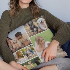 a woman sitting on a couch holding a pillow with pictures of people and dogs printed on it