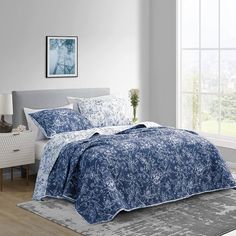 a bed with blue and white comforters in a room