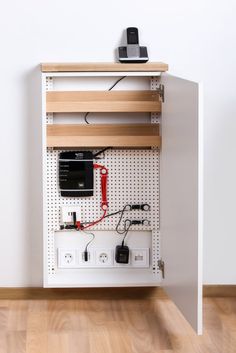 an electronic device is on top of a shelf with wires and plugs attached to it