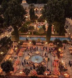 an aerial view of a courtyard with tables and umbrellas in the center at night