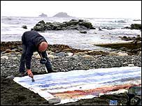 a man standing on top of a beach next to the ocean