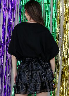 This sequin tiered skirt has a mask design on the front. Madeline is wearing a small. Sequin Mini Skirt For Night Out In Fall, Fall Sequined Mini Skirt For Night Out, Fall Party Mini Skirt With Ruffles, Ruffled Mini Skirt For Fall Parties, Black Mini Skirt With Contrast Sequin For Party Season, Black Mini Skirt With Contrast Sequin For Night Out, Black Contrast Sequin Mini Skirt For Party Season, Glamorous Black Mini Skirt With Contrast Sequin, Tiered Skirt For Party Season Night Out