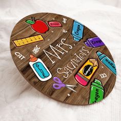 a wooden sign with school supplies painted on it