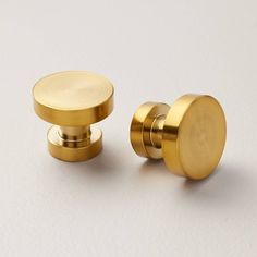 two brass knobs on a white background