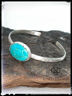 This skinny stacker cuff has a beautiful Stone Mountain turquoise set in sterling and fine silver.   The bezel is scalloped and polished to a satin finish.  The sterling band is 1/4" wide and has a swirl detail   The turquoise is slightly darker than it shows in the pictures, with deep blue and green and a golden matrix.  There are so many details in this bracelet.   Stunning worn alone or stacked with more bracelets!   This measures 2.25" across with a 1" opening.  The inside band measures 6" and 1" opening.  It can be adjusted slightly Handcrafted here, in my New Mexico studio FREE SHIPPING! Classic Adjustable Turquoise Cuff Bracelet, Southwestern Oval Sterling Silver Cuff Bracelet, Oval Southwestern Sterling Silver Cuff Bracelet, Stamped Turquoise Sterling Silver Bracelet, Sterling Silver Turquoise Stamped Bracelet, Southwestern Style Oval Sterling Silver Cuff Bracelet, Stamped Sterling Silver Bracelet In Turquoise, Oval Sterling Silver Cuff Bracelet In Southwestern Style, Classic Turquoise Cuff Bracelet Gift