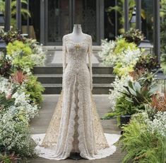 a dress on display in front of some flowers