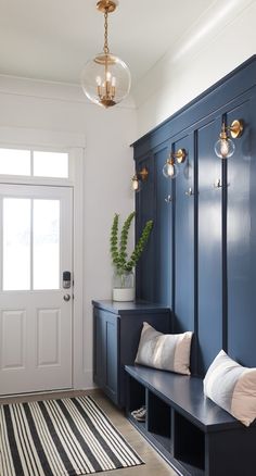 the entryway is decorated in blue and white with striped rugs on the floor