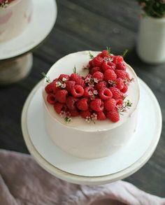 a white cake topped with raspberries and flowers