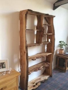 a wooden shelf sitting on top of a carpeted floor in a living room next to a window