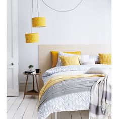 a bedroom with white walls and yellow accents