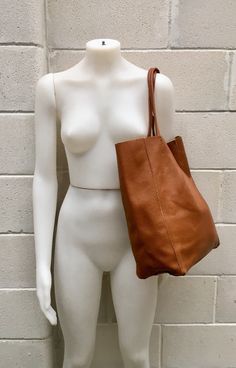 Large tote leather bag in dark CAMEL BROWN. Saddle brown shoulder bag. Tan color natural GENUINE leather. Large enough for books or a laptop, tablet, cosmetics bag etc. Leather shopper. The inside of the bag is not lined (although properly finished!) . We added a small leather pouch on the inner part of the bag (4th pic) The bag can be closed by 2 leather straps attached to each side. Excellent quality soft but strong genuine leather. Width upper part: 41cm - 16 inch Height: 38 cm - 15 inch This Dark Tan Leather Bag For On-the-go, Modern Brown Shoulder Bag For Shopping, Brown Modern Shoulder Bag For Shopping, Cognac Leather Backpack With Leather Handles For Daily Use, Modern Brown Tote Shoulder Bag, Camel Tote Satchel For On-the-go, Everyday Light Brown Rectangular Hobo Bag, Brown Leather Shoulder Bag With Leather Handles, Everyday Cognac Hobo Bag With Leather Lining