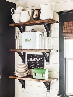 the shelves in this kitchen are filled with dishes and drinks, including milk jugs