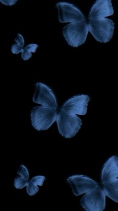 several blue butterflies flying in the dark