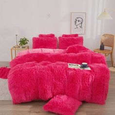 a bright pink bed with fluffy pillows on it