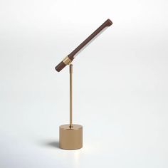 a gold and brown table lamp with a wooden handle on a round base, against a white background