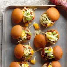 mini sandwiches with cheese and other toppings on a baking tray, ready to be eaten