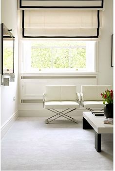 a living room with two white chairs and a coffee table