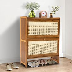 a pair of shoes is sitting on the floor next to a cabinet with two drawers