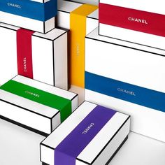 several different colored boxes stacked on top of each other with the word chanel painted on them