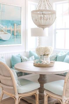 a dining room table with chairs and a chandelier hanging from it's ceiling