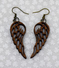 pair of wooden angel wings earrings on white background