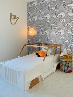 a child's bedroom with a white bed and wallpaper in the background,