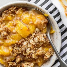 a bowl filled with oatmeal and fruit on top of a striped table cloth