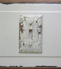 an old white light switch cover with peeling paint